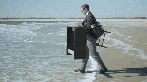 un homme en costume qui installe son bureau sur la plage et deviens digital nomade